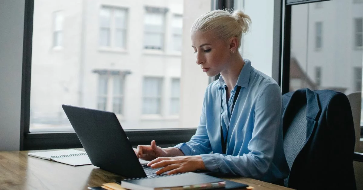 Woman in the office browsing the internet on her laptop